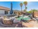 Inviting backyard featuring a pool, lush palm trees, and a well-equipped outdoor kitchen area at 13630 W Redfield Rd, Surprise, AZ 85379