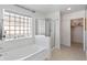 Bright bathroom featuring a tub, glass block window, and shower at 13630 W Redfield Rd, Surprise, AZ 85379