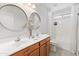 Bright bathroom featuring double sinks, round mirrors, and a shower-tub combo with stylish fixtures at 13630 W Redfield Rd, Surprise, AZ 85379