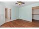 Bright bedroom with hardwood flooring, a ceiling fan, walk-in closet, and an ensuite bathroom at 13630 W Redfield Rd, Surprise, AZ 85379