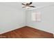 Empty bedroom with hardwood floors, a ceiling fan, and a window allowing ample natural light at 13630 W Redfield Rd, Surprise, AZ 85379