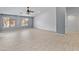 Bright living room with tile flooring, neutral walls, ceiling fan, and natural lighting from two windows at 13630 W Redfield Rd, Surprise, AZ 85379
