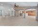 Spacious living room with tile floors, open layout, and decorative stone columns leading to the kitchen area at 13630 W Redfield Rd, Surprise, AZ 85379