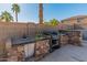Outdoor kitchen equipped with a sink, grill, and stone countertops perfect for backyard barbecues at 13630 W Redfield Rd, Surprise, AZ 85379