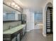 Modern bathroom showcasing dual glass vessel sinks, a large mirror, and a separate tub area at 15828 N 10Th Pl, Phoenix, AZ 85022