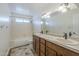 Traditional bathroom with double sinks and a bathtub with shower, offering functionality and convenience at 15828 N 10Th Pl, Phoenix, AZ 85022