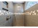 Modern shower with decorative tiles, rainfall shower head, and a window letting in lots of light at 15828 N 10Th Pl, Phoenix, AZ 85022