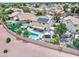 Aerial view of a private backyard oasis with a pool, fire pit area, and covered seating areas at 16197 N 157Th Ave, Surprise, AZ 85374
