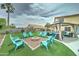 Inviting backyard featuring a fire pit surrounded by bright blue Adirondack chairs and a covered patio area at 16197 N 157Th Ave, Surprise, AZ 85374