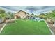 Expansive backyard featuring lush green turf, a pool, a gazebo, and a charming fire pit area at 16197 N 157Th Ave, Surprise, AZ 85374