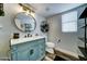 Charming bathroom with a modern vanity, round mirror, and a window providing natural light at 16197 N 157Th Ave, Surprise, AZ 85374