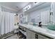 Updated bathroom with a gray vanity, white marble countertop, and a shower featuring a white shower curtain at 16197 N 157Th Ave, Surprise, AZ 85374