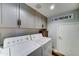 Functional laundry room with gray cabinetry, a laundry sign, and side-by-side washer and dryer at 16197 N 157Th Ave, Surprise, AZ 85374