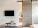 Bright bedroom with a modern design, a large sliding barn door to the bathroom, and a television at 1659 N Channing --, Mesa, AZ 85207