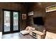 Stylish den features dark wood walls, a TV, and an outdoor view through French doors at 1659 N Channing --, Mesa, AZ 85207