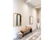 Hallway view featuring stylish mirrors, a wooden bench with cushions, and elegant decor elements at 1659 N Channing --, Mesa, AZ 85207