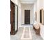 Elegant hallway with a decorative rug, stylish mirrors, bench, and doorway, creating a welcoming and sophisticated ambiance at 1659 N Channing --, Mesa, AZ 85207