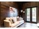 Cozy living room boasts a comfortable couch and stylish art against dark wood paneled walls at 1659 N Channing --, Mesa, AZ 85207