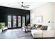 Comfortable living room with a gray sofa, white chair, and black framed french doors leading to outdoor space at 1659 N Channing --, Mesa, AZ 85207