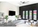Comfortable living room with media center, large doors, and a ceiling fan for relaxing and entertaining at 1659 N Channing --, Mesa, AZ 85207