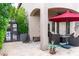 Covered patio with outdoor seating, a red umbrella, and views of lush greenery at 1659 N Channing --, Mesa, AZ 85207