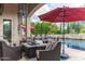 Outdoor seating by the pool with a red umbrella and well-manicured landscaping at 1659 N Channing --, Mesa, AZ 85207