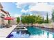 Inviting backyard pool featuring a spa, red umbrella, lounge chairs, and beautifully manicured landscaping at 1659 N Channing --, Mesa, AZ 85207