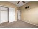Cozy bedroom with ceiling fan, carpet, closet with shelves, and wall-mounted TV at 18434 E El Buho Pequeno Rd, Gold Canyon, AZ 85118