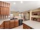 Open kitchen showcasing stainless steel appliances, a central island, and a view of the adjacent dining and living areas at 18434 E El Buho Pequeno Rd, Gold Canyon, AZ 85118