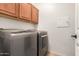 Laundry room showcasing modern washer and dryer units with upper cabinets for storage at 18434 E El Buho Pequeno Rd, Gold Canyon, AZ 85118