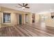 Spacious living room featuring wood-look tile flooring, a ceiling fan, and abundant natural light at 18434 E El Buho Pequeno Rd, Gold Canyon, AZ 85118