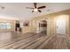 Spacious living room featuring wood-look tile flooring, a ceiling fan, and abundant natural light at 18434 E El Buho Pequeno Rd, Gold Canyon, AZ 85118