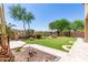 Lush backyard featuring artificial turf, a decorative water feature, and desert landscaping at 18547 W Sweet Acacia Dr, Goodyear, AZ 85338