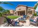 Inviting backyard with travertine patio, a fire pit, and a view of the desert landscape at 18547 W Sweet Acacia Dr, Goodyear, AZ 85338