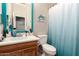 Bathroom features a modern sink, wooden vanity, and a decorative blue framed mirror above the sink at 18547 W Sweet Acacia Dr, Goodyear, AZ 85338
