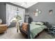 Comfortable bedroom featuring a ceiling fan, gray walls, and a large window with decorative curtains at 18547 W Sweet Acacia Dr, Goodyear, AZ 85338