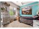 A cozy bedroom decorated with a unique mountain mural, ceiling fan, and an outdoor view at 18547 W Sweet Acacia Dr, Goodyear, AZ 85338