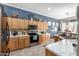 Well-equipped kitchen with wooden cabinetry, stainless steel appliances, and marble countertops at 18547 W Sweet Acacia Dr, Goodyear, AZ 85338