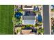 Aerial view of the home showing solar panels, putting green, pool, and green field next to the property at 1974 E Dubois Ave, Gilbert, AZ 85298