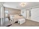 Bright bedroom featuring a stylish light fixture, neutral walls, and a barn door to an en-suite bathroom at 1974 E Dubois Ave, Gilbert, AZ 85298