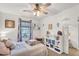 Bright bedroom featuring a ceiling fan, plush bedding, window with curtains, and a charming bookshelf at 1974 E Dubois Ave, Gilbert, AZ 85298