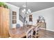 Dining room with wooden table, chandelier, wall decor and view to the staircase and other rooms at 1974 E Dubois Ave, Gilbert, AZ 85298