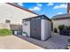 Backyard storage shed with dual doors and upper window, offering secure storage and appealing design at 1974 E Dubois Ave, Gilbert, AZ 85298