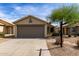 Single story home featuring a two car garage, desert landscaping, and light beige stucco exterior at 2153 E Crest Ln, Phoenix, AZ 85024