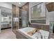 Bathroom featuring a separate glass shower and tub with dark tile accents and a barn-style window blind at 22639 E Avenida Del Valle --, Queen Creek, AZ 85142