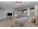 Well-lit bedroom with a ceiling fan, light plank flooring, light walls and large windows for ample natural light at 22639 E Avenida Del Valle --, Queen Creek, AZ 85142