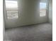 Bedroom featuring neutral carpet, white walls, and two windows offering natural light at 24268 W Pecan Rd, Buckeye, AZ 85326