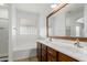 A bright bathroom features double sinks, wood cabinets, and a glass block window above the soaking tub at 28232 N Abby Cir, San Tan Valley, AZ 85143
