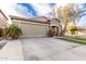 Beige single-story home featuring brick accents, a two-car garage, and desert landscaping at 28232 N Abby Cir, San Tan Valley, AZ 85143
