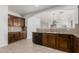 Kitchen featuring wood cabinetry, granite countertops, a tile backsplash, and black appliances at 28232 N Abby Cir, San Tan Valley, AZ 85143